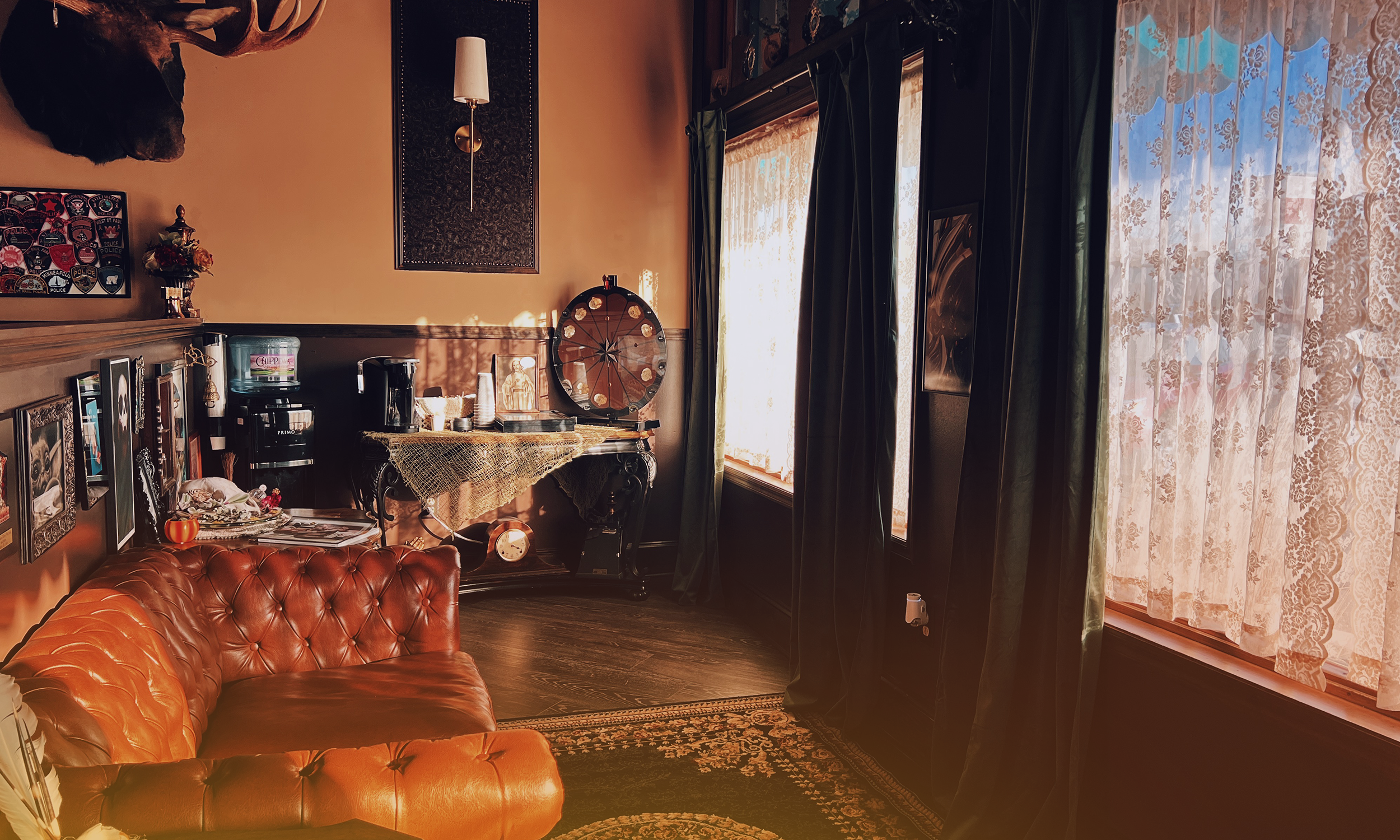 Cozy tattoo shop waiting area at Lady Liberty Tattoo in Saint Paul Park, MN. Vintage leather couch, warm lighting, and antique decor create a welcoming atmosphere.